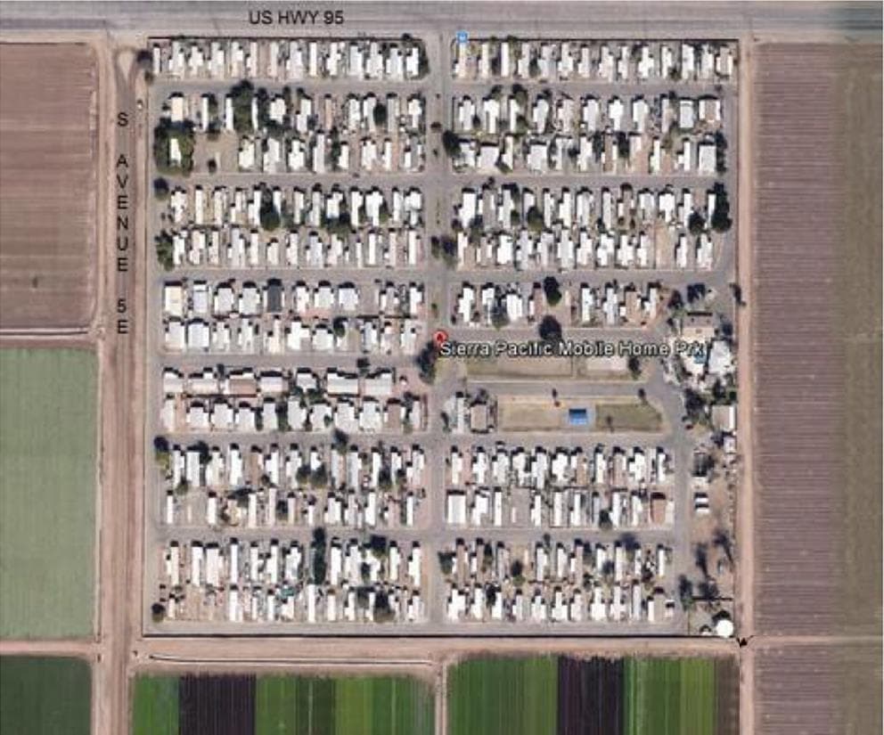 An aerial photograph of Sierra Pacific Manufactured Housing Community in Yuma, showing the streets, homes and surrounding farmland.